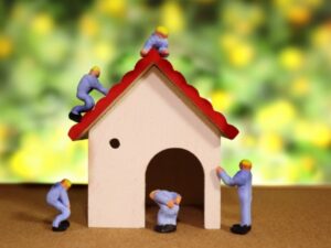 作業服の人形たちが屋根や外壁を修繕しているリフォームのイメージ写真