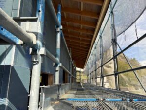 養生シートと足場で囲まれた塗装工事中の通路